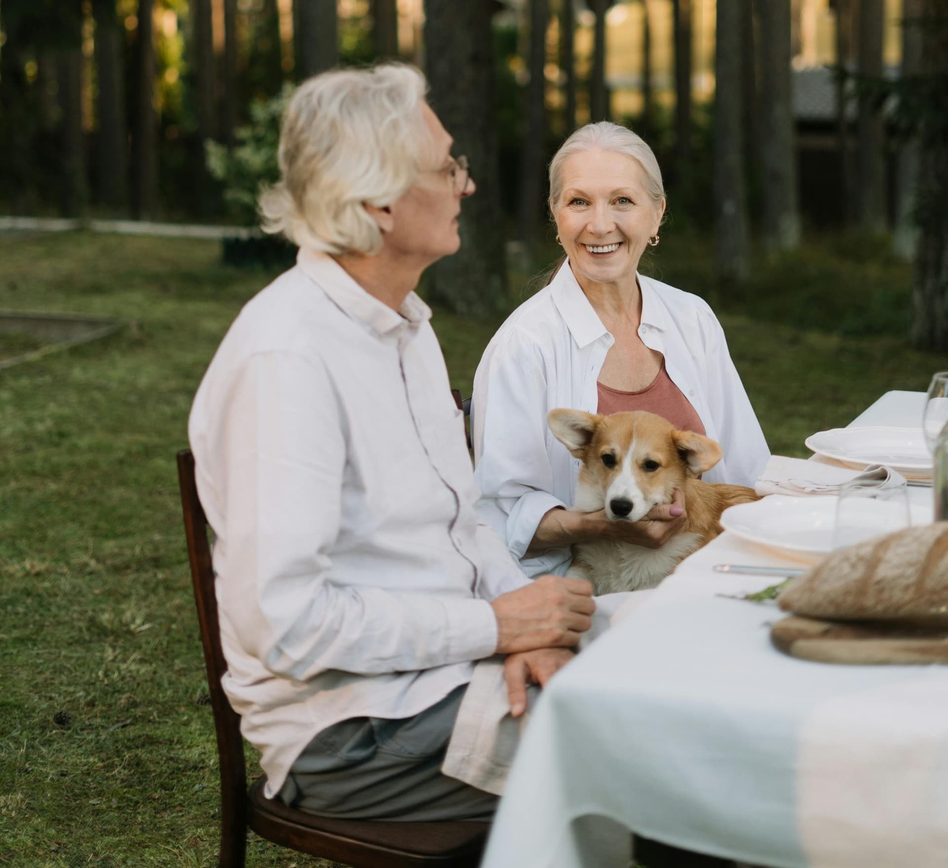 An elderly couple enjoying time together outdoors with their dog
